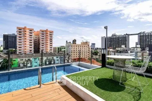 Stunning rooftop pool with city view and seating area, perfect for relaxation.
