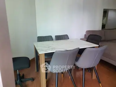 Modern dining area with marble table and stylish chairs in a cozy living space.