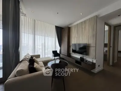 Modern living room with sleek furniture and large windows offering city views.