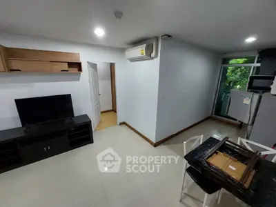 Modern living room with TV, air conditioning, and balcony access in a cozy apartment.