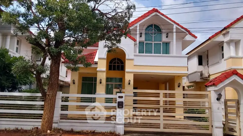 Charming two-story house with red roof and spacious front yard in a serene neighborhood.
