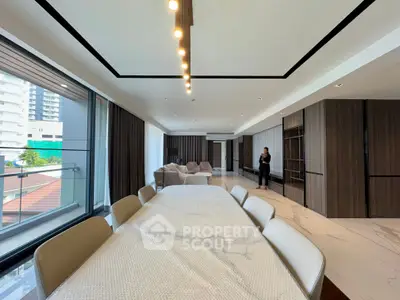 Spacious modern living room with elegant dining area and large windows offering natural light.