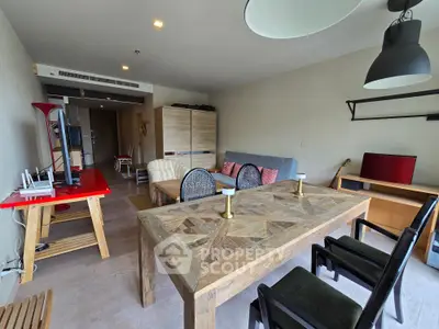 Spacious living room with rustic dining table and modern decor in a stylish apartment.