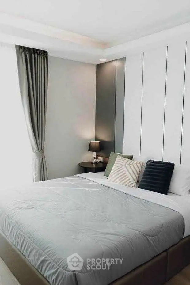 Modern bedroom with stylish decor and cozy ambiance, featuring elegant curtains and a comfortable bed.