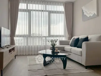 Modern living room with large window, stylish furniture, and elegant decor.