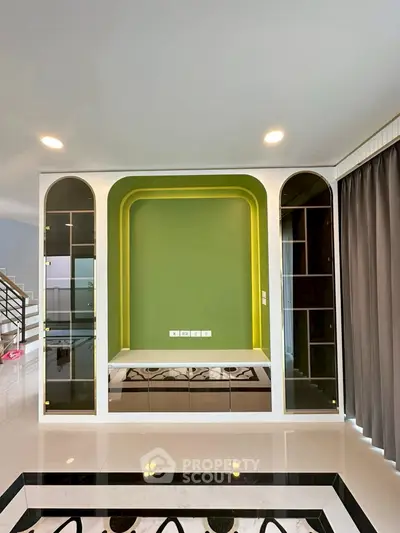 Modern living room with stylish green accent wall and built-in shelving