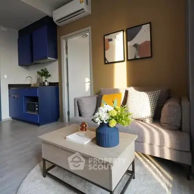 Chic modern living room with a cozy sofa, vibrant blue kitchen cabinets, and sleek design elements, perfect for urban living.