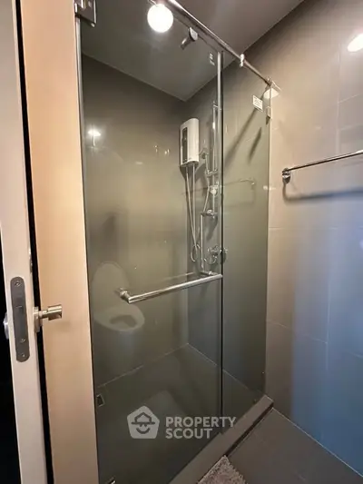 Modern bathroom with glass shower enclosure and sleek fixtures, perfect for a contemporary home.