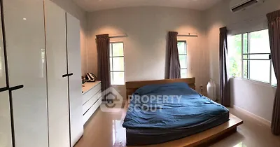 Spacious bedroom with modern design and large windows for natural light.
