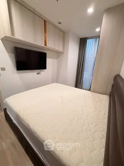 Modern bedroom with wall-mounted TV and stylish storage cabinets