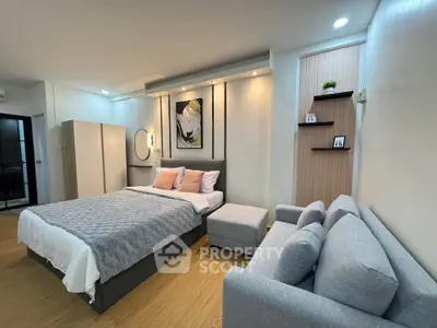 Modern bedroom with stylish decor and cozy seating area, perfect for relaxation and comfort.