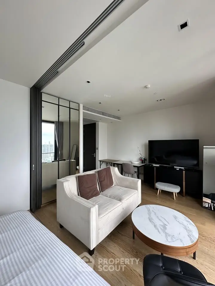 Modern living room with sleek furniture and city view, featuring a cozy sofa and stylish decor.