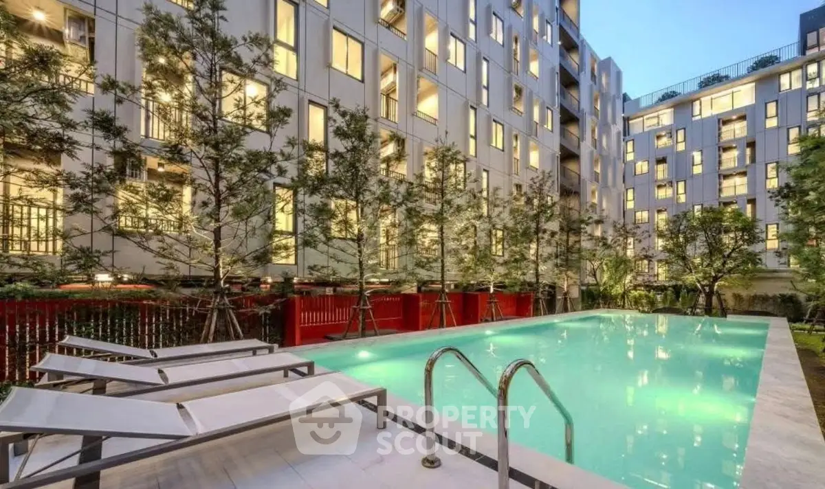 Luxurious apartment complex with illuminated pool and modern architecture