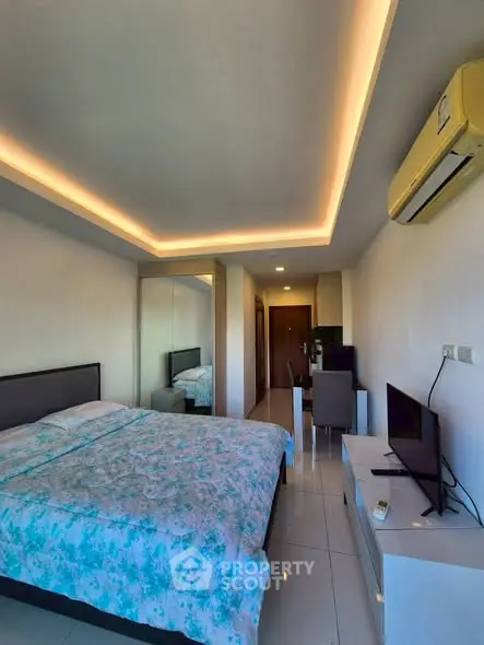 Modern bedroom with sleek design and ambient lighting, featuring a cozy bed and air conditioning.