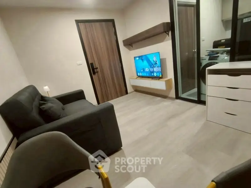 Modern living room with sleek furniture and wall-mounted TV in a cozy apartment.