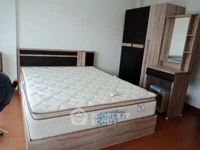 Spacious bedroom with modern wooden furniture and comfortable mattress