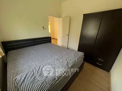 Cozy bedroom with modern dark wood furniture and checkered bedding, perfect for relaxation.