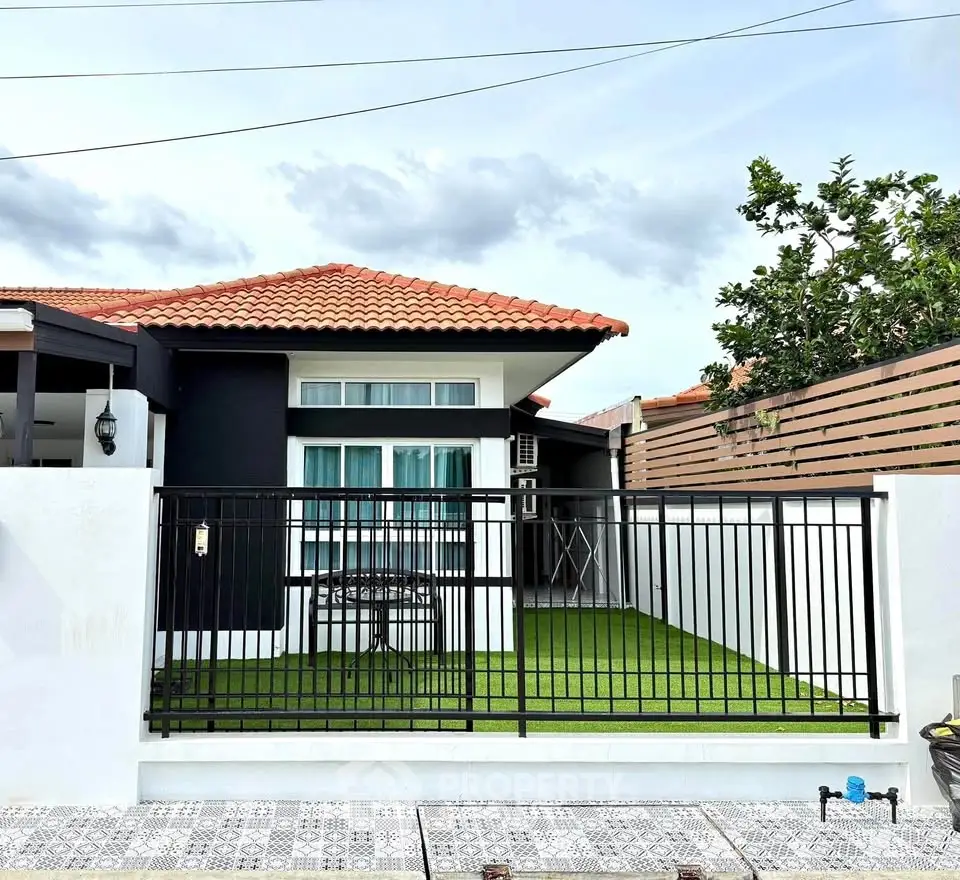Charming single-story home with red-tiled roof and fenced front yard, perfect for family living.
