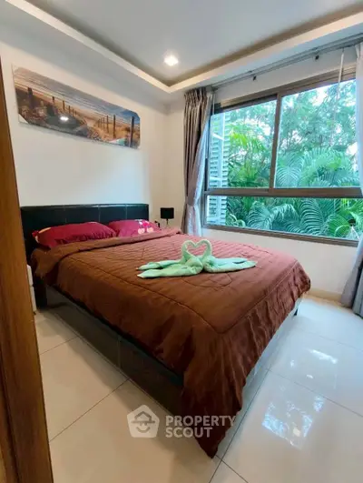 Cozy bedroom with large window and lush garden view, featuring elegant decor and natural light.