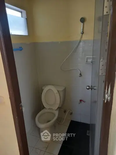 Compact bathroom with shower and toilet in a cozy real estate unit.