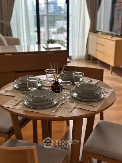 Modern dining area with elegant tableware and city view, perfect for urban living.