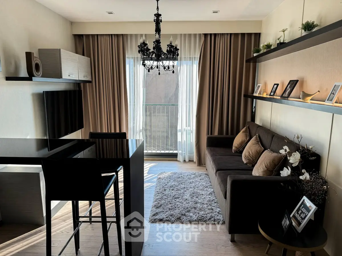 Stylish living room with elegant chandelier and cozy sofa in modern apartment.