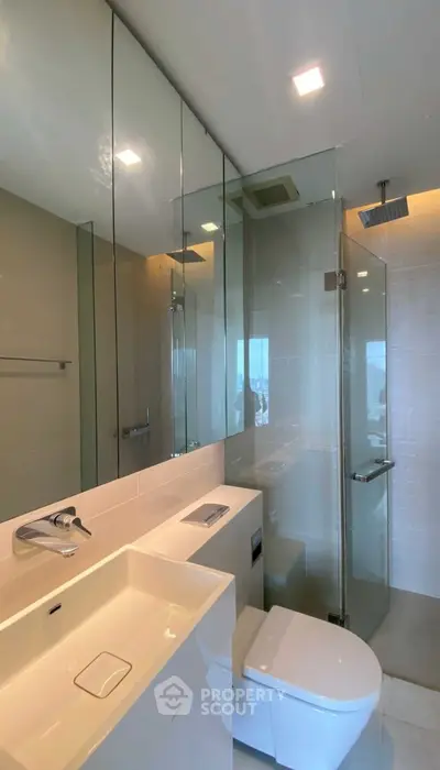 Modern bathroom with glass shower and sleek fixtures in luxury apartment
