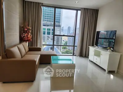 Modern living room with city view, stylish sofa, and sleek TV setup.