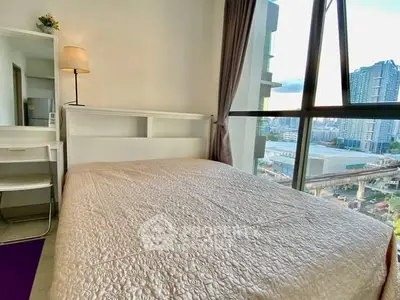 Cozy bedroom with city view and natural light, perfect for urban living.
