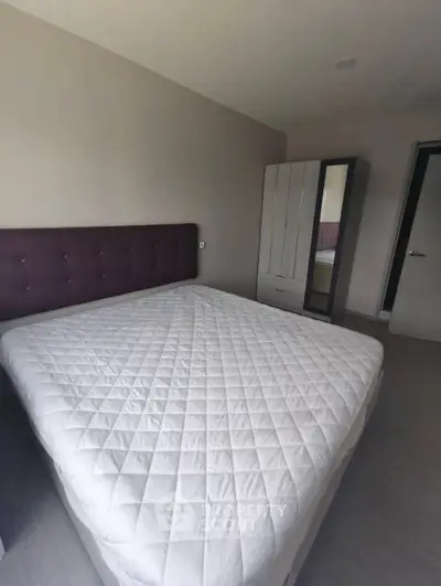 Spacious bedroom with modern decor and large bed, perfect for relaxation.