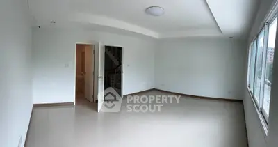 Spacious unfurnished room with large windows and neutral tones, ideal for customization.