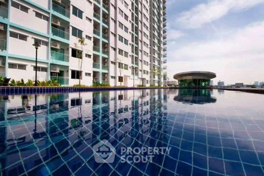 Modern high-rise building with luxurious pool and city skyline view.