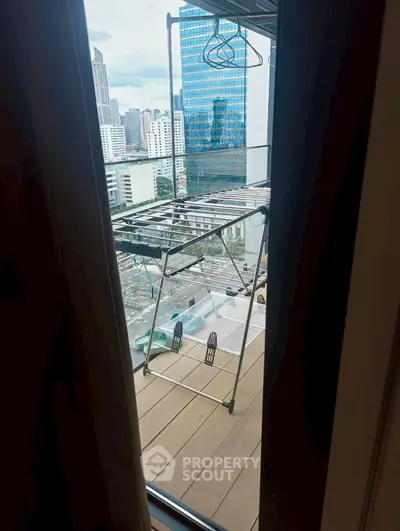 Urban balcony view with drying rack and cityscape backdrop, ideal for compact living spaces.