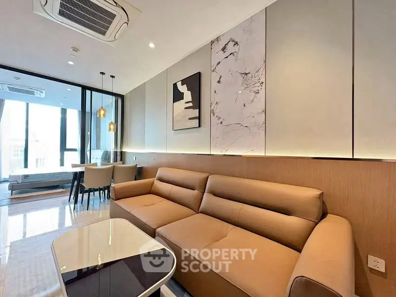 Modern living room with stylish decor and large windows offering natural light.
