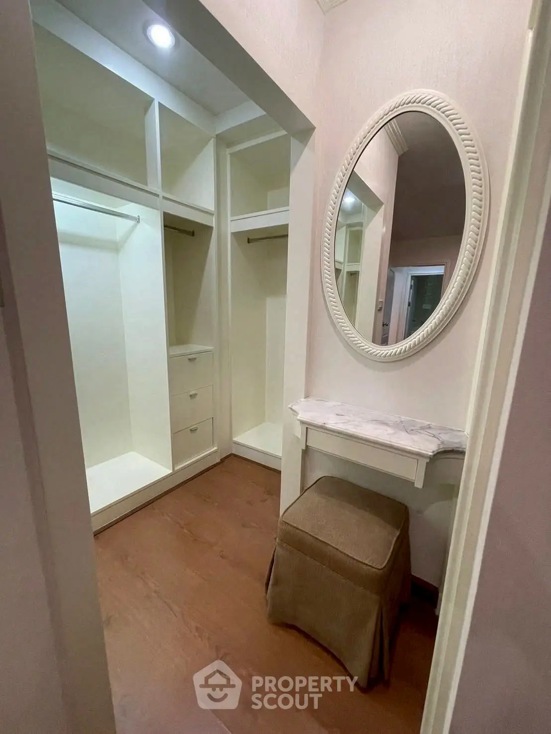 Spacious walk-in closet with elegant vanity and ample storage space.