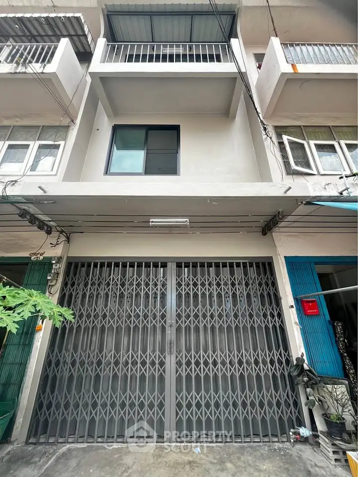 Modern urban building facade with secure metal gate and balcony