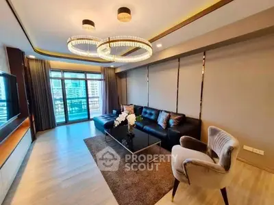 Luxurious living room with modern chandelier and elegant furnishings in high-rise apartment.