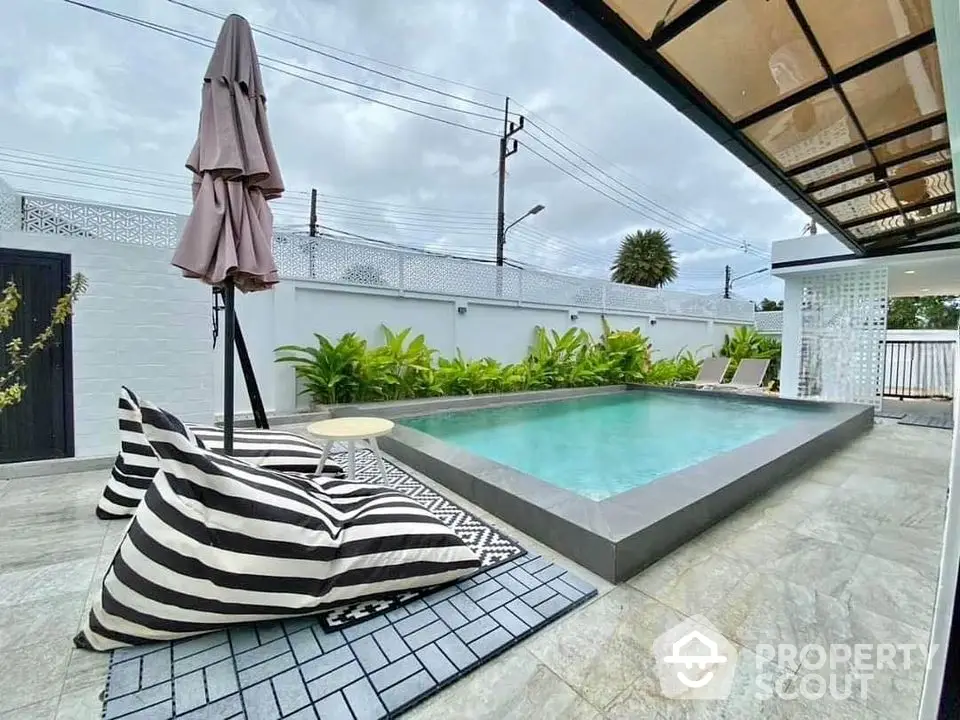 Luxurious outdoor pool area with stylish seating and lush greenery