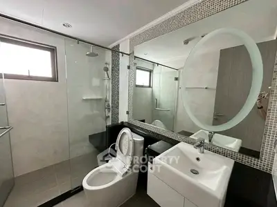 Modern bathroom with glass shower and stylish vanity in a contemporary home.