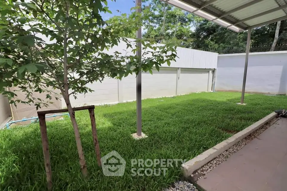 Charming garden with lush greenery and covered patio area, perfect for outdoor relaxation.
