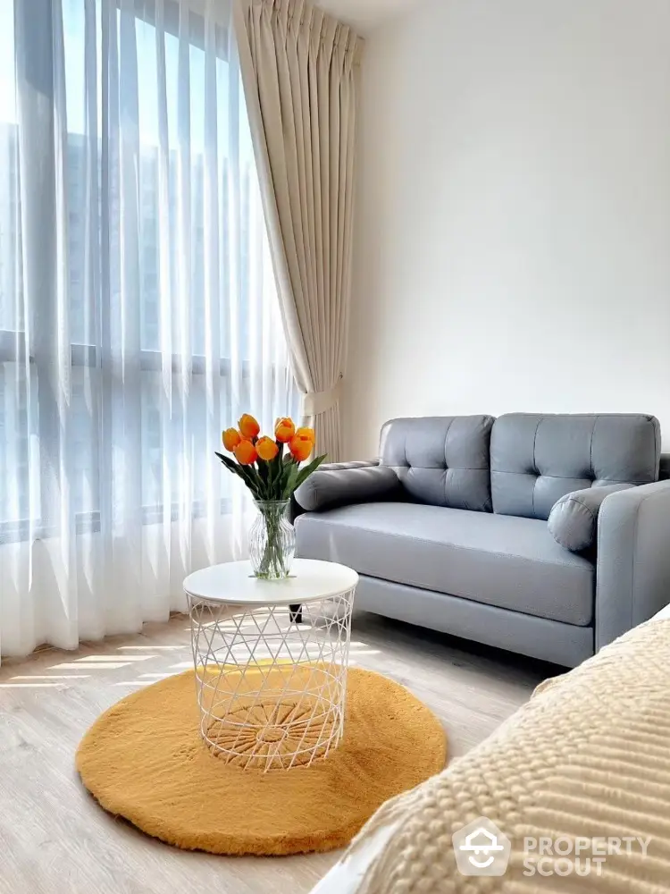 Bright living room with modern gray sofa and vibrant orange accents