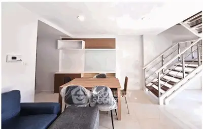 Modern living room with stylish staircase and dining area in a contemporary home.
