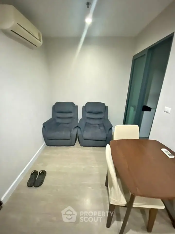 Cozy living room with modern furniture and air conditioning, perfect for relaxation.