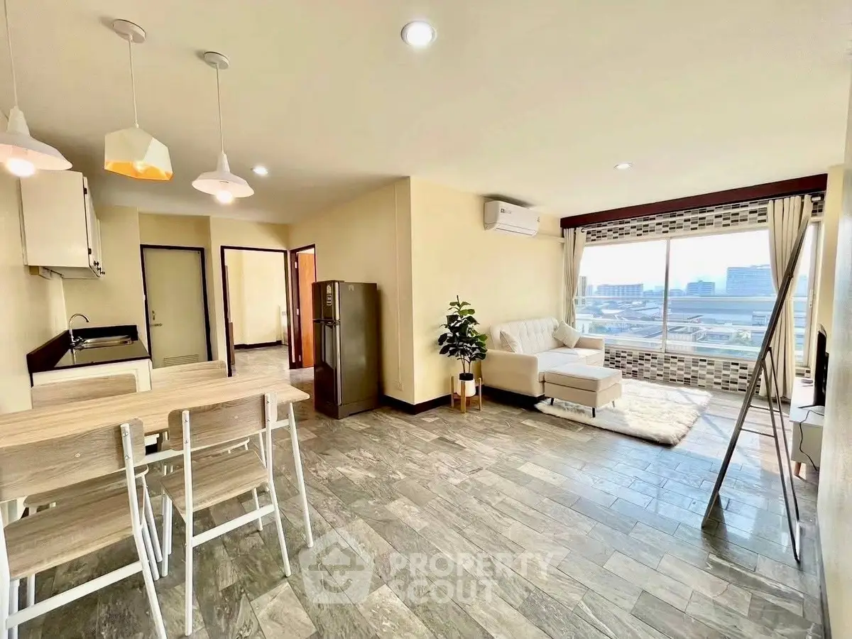 Spacious open-plan living room with modern kitchen and city view