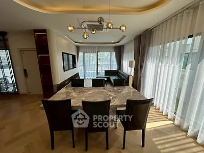Spacious modern living room with elegant dining area and large windows for natural light.