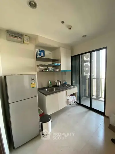 Modern compact kitchen with balcony access and sleek appliances