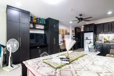 Spacious bedroom with modern dark wood cabinetry and ceiling fan, featuring cozy decor and open layout.