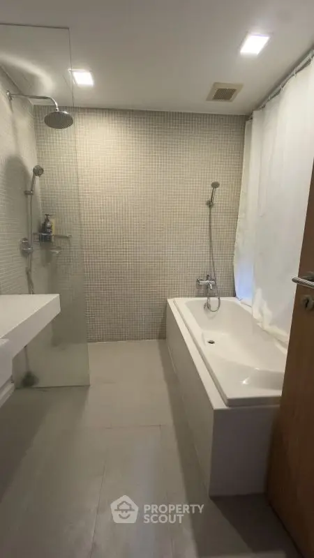 Modern bathroom with bathtub and shower in sleek design