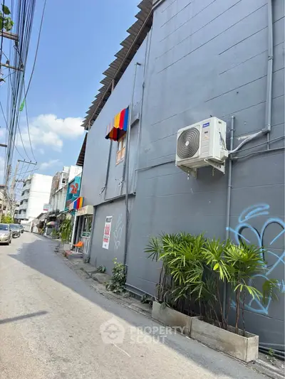 Charming urban street view with colorful awnings and modern air conditioning unit.