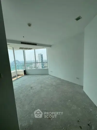 Spacious unfurnished room with large windows offering a stunning city view, perfect for customization.